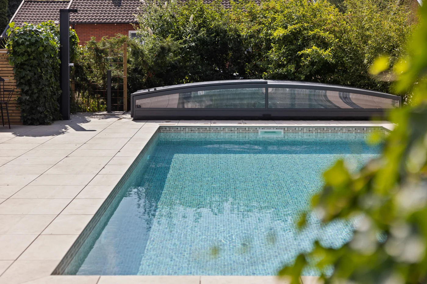 Pool med mosaikliner och pooltak från Österlens Poolcenter.