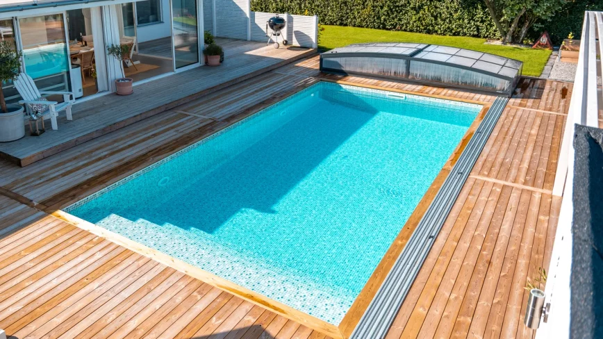Pool med mosaikliner, trädäck och pooltak från Österlens Poolcenter.